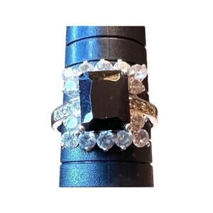 Ring black center stone surrounded by round inlaid crystals on band S 9